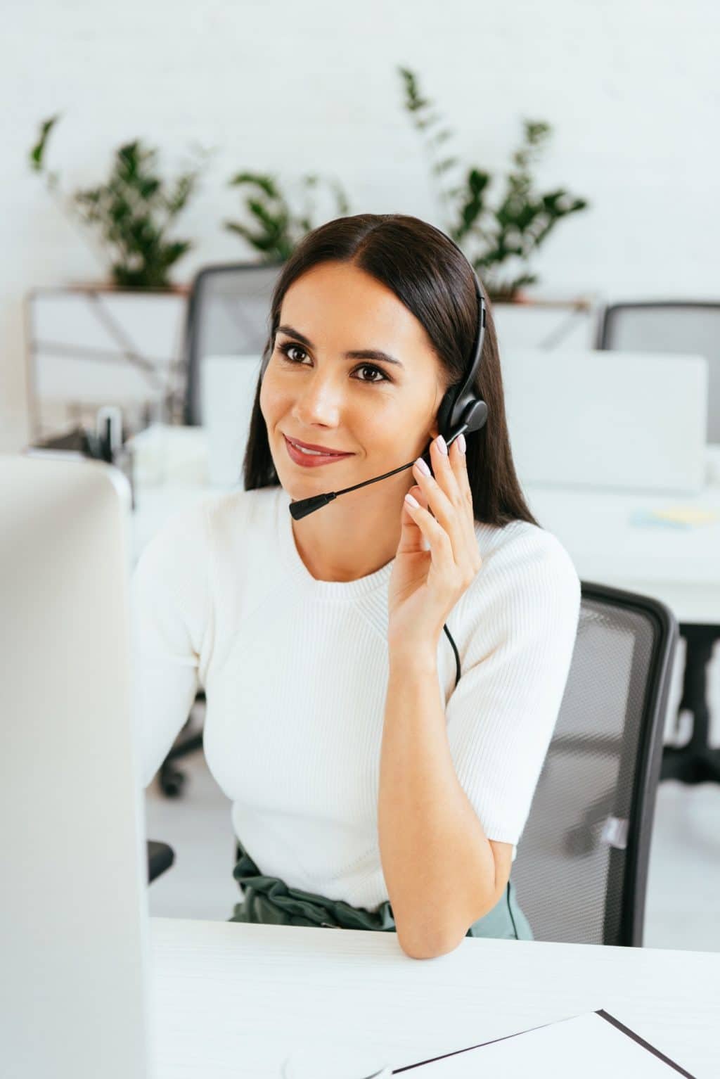selective focus of cheerful broker touching headset while working in call center